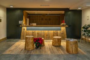 a lobby with three logs and a counter with candles at Hotel Petit Palais in Breuil-Cervinia