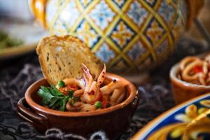 a bowl of food with shrimp and a slice of bread at Grand Hotel Il Ninfeo in Gaeta