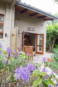 a house with purple flowers in front of it at Theebos in Strand