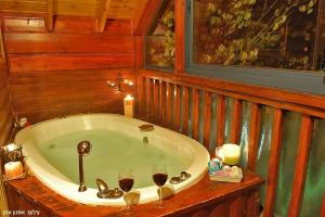 una vasca da bagno in camera con due bicchieri di vino di Nofesh Ne'eman ad Amirim