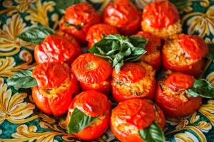 a plate of red tomatoes with green leaves on it at Grand Hotel Il Ninfeo in Gaeta