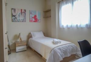 een slaapkamer met een bed, een stoel en een raam bij A&G APARTMENT in Athene