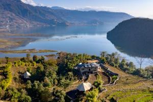 z góry widok na dom na wzgórzu obok jeziora w obiekcie The Pavilions Himalayas Lake View w mieście Pokhara