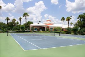 un campo da tennis di fronte a un edificio con palme di Summer Bay Orlando by Exploria Resorts a Orlando