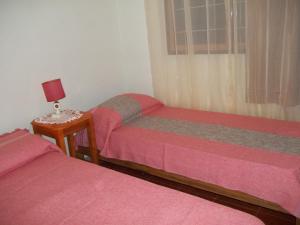 um quarto com duas camas e um candeeiro sobre uma mesa em Cabañas El Hornero em Puerto Iguazú