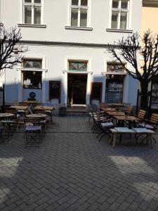 a patio with tables and chairs in front of a building at JAM Luxury Apartment in Győr