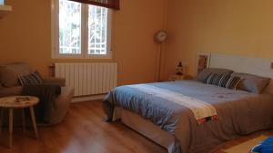 a bedroom with a bed and a couch and a window at La casa del Duero in Tordesillas