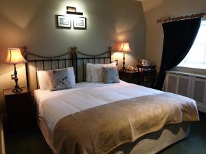 a bedroom with a large white bed with two lamps at The Listowel Arms Hotel in Listowel