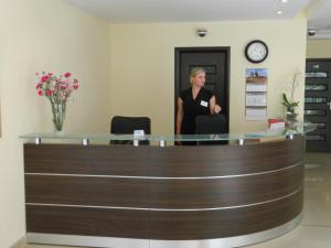 a woman standing at the reception desk of a dermatologists office at Fala1 Ośrodek Wypoczynkowy in Gdańsk