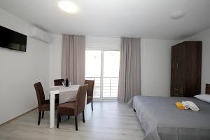 a bedroom with a bed and a table and chairs at Rosi`s Apartment in Sutomore