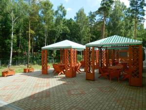 two pavilions with tables and chairs in a park at Fala1 Ośrodek Wypoczynkowy in Gdańsk