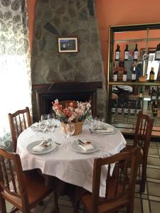 a table with wine glasses and flowers on it at Hostal Asador La Montaña in Triollo