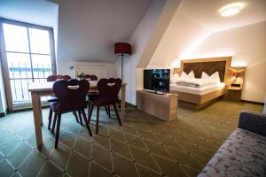 um quarto com uma cama, uma mesa e cadeiras em Hohenester Gasthaus & Hotel em Markt Indersdorf