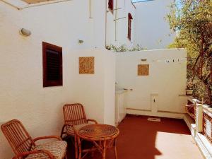 eine Terrasse mit 2 Stühlen, einem Tisch und einem Gebäude in der Unterkunft Casa al Mulino in San Vito lo Capo
