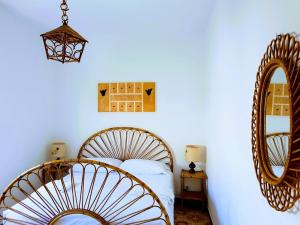een slaapkamer met een bed en een spiegel bij Casa al Mulino in San Vito lo Capo