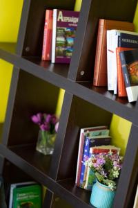a book shelf with books and flowers on it at Travel Inn Hostel in Baku
