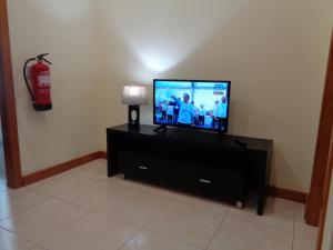 a living room with a flat screen tv and a fire extinguisher at Dona Matilde in Ponta Delgada
