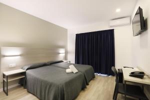 Säng eller sängar i ett rum på Hotel Brasil