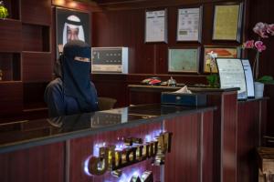 a person sitting at a counter in a bar at Viola Hotel in Jazan