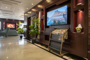 a hotel lobby with a flat screen tv on the wall at Viola Hotel in Jazan