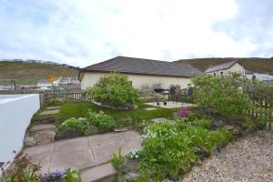 a house with a garden with flowers in the yard at Beach View Apartments in Porthtowan