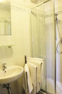 a bathroom with a sink and a shower with towels at Hotel San Lorenzo in Florence