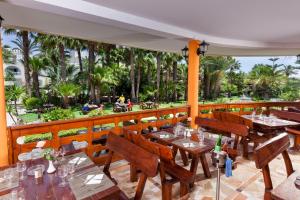 a restaurant with tables and chairs and palm trees at TUI MAGIC LIFE Africana in Hammamet