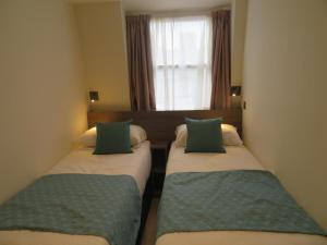 Postel nebo postele na pokoji v ubytování Glendale Hyde Park Hotel
