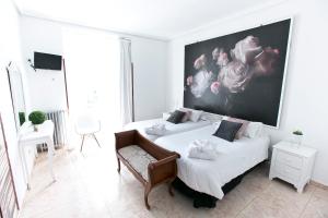 um quarto com duas camas e uma grande pintura na parede em Vázquez de Mella Gran Vía em Madrid