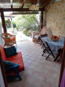 un patio con tavolo, sedie, tavolo e cesto di frutta di Le Case di Vito a Favignana