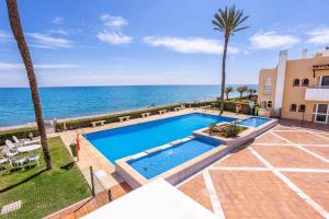 a swimming pool with the ocean in the background at Beach View Playa Del Moral in Estepona