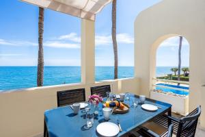 een eetkamer met een tafel en uitzicht op de oceaan bij Beach View Playa Del Moral in Estepona