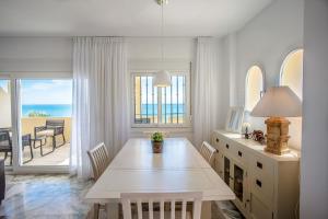 een eetkamer met een tafel en uitzicht op de oceaan bij Beach View Playa Del Moral in Estepona