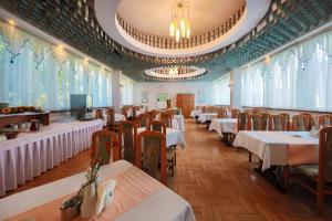 jadalnia ze stołami, krzesłami i oknami w obiekcie Hotel *** NAT Krynica Zdrój w mieście Krynica Zdrój