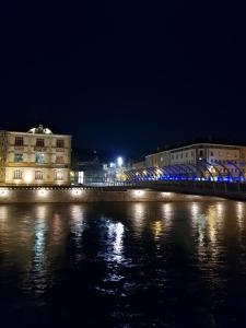 a city at night with a river and buildings at Nid douillet au centre ville in Épinal