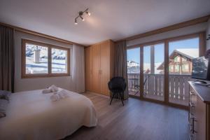 a bedroom with a bed and a balcony with mountains at Chalet Brunner 2 in Wengen