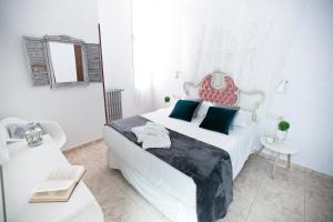 ein weißes Schlafzimmer mit einem großen Bett mit blauen Kissen in der Unterkunft Vázquez de Mella Gran Vía in Madrid