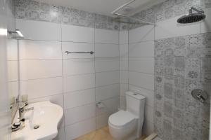 Un baño blanco con inodoro y lavabo. en Promenade Hotel, en Shkodër 37 fotos más