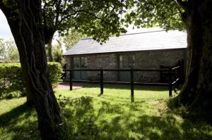 un bâtiment en briques avec une fenêtre dans l'herbe dans l'établissement Charming old stables studio cottage, à Clonakilty