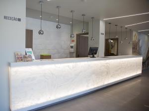 a long white counter in a room with mirrors at Mafra Hotel in Mafra