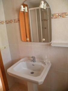 uma casa de banho com um lavatório branco e um espelho. em El Pato 4 - Fincas Arena em Benidorm
