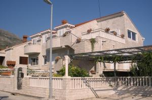 a large house with a fence in front of it at Apartments Sunce in Mlini
