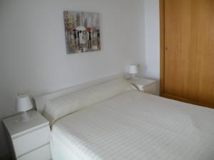 ベニドルムにあるTorre Lugano - Fincas Arenaのベッドルーム1室(白いベッド1台、ナイトスタンド2台付)