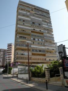 duży wysoki budynek przy ulicy miejskiej w obiekcie Principado Centro III - Fincas Arena w mieście Benidorm