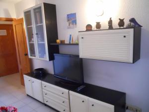 a living room with a tv on a cabinet at San Francisco - Fincas Arena in Benidorm