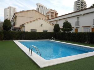 a swimming pool in the yard of a building at Rinconada Real - Fincas Arena in Benidorm