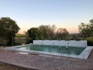 una piscina con una pared de hormigón y agua en Casa de la vega, en Almodóvar del Río