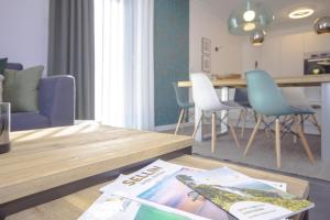 uma sala de estar com uma mesa com uma revista em Südstrandquartier - Ferienwohnung Loft em Ostseebad Sellin