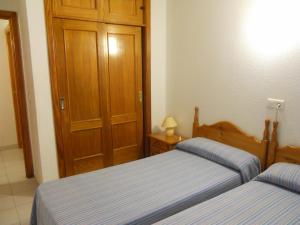 - une chambre avec 2 lits et une porte en bois dans l'établissement San Francisco - Fincas Arena, à Benidorm 8 autres photos