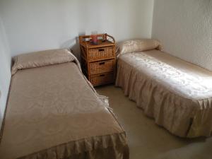 a room with two beds and a wooden dresser at Gemelos 2 II - Fincas Arena in Benidorm